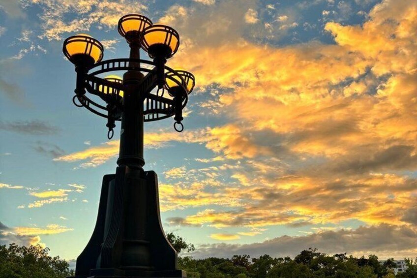 A street lamp with multiple lights against a sunset sky. 5