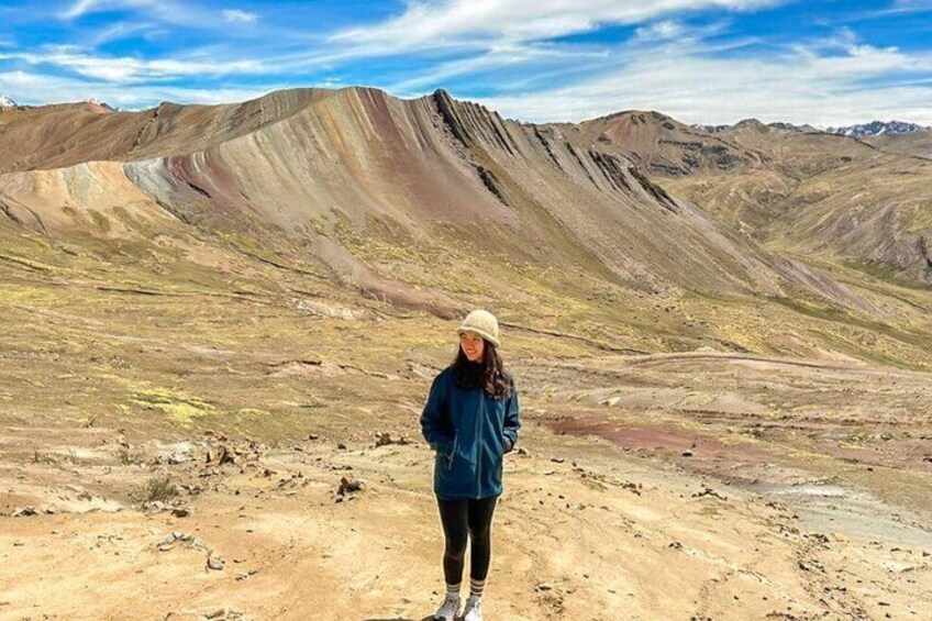 A person standing on a barren landscape with rolling hills and a clear sky. 5