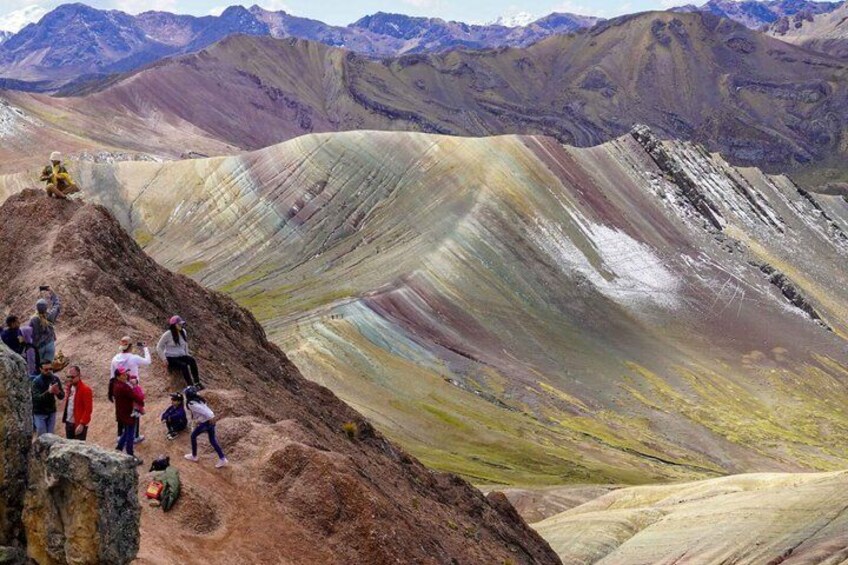 A group of people hiking on a colorful mountain ridge. 2
