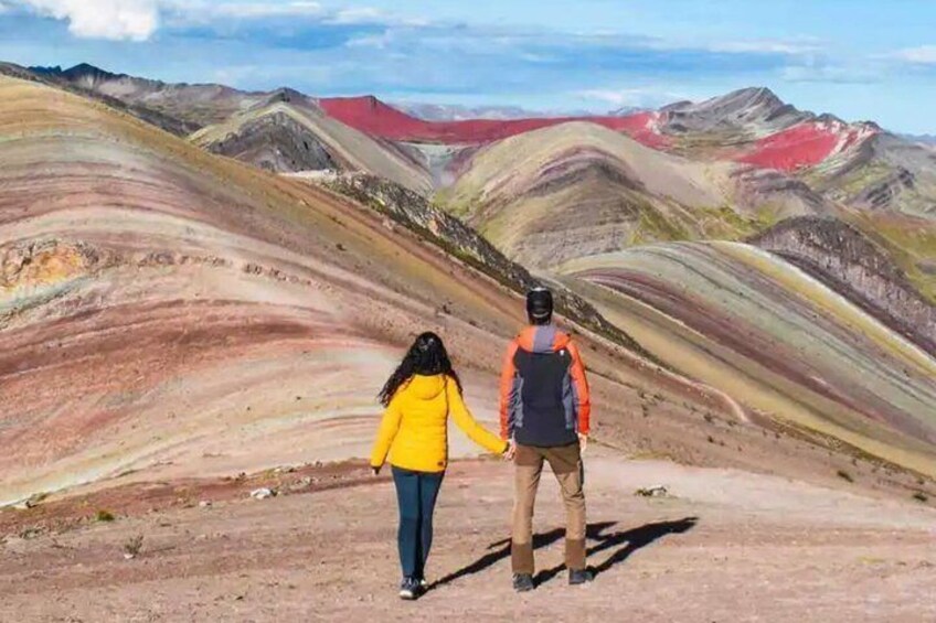 Two people walking on a colorful mountain trail. 4