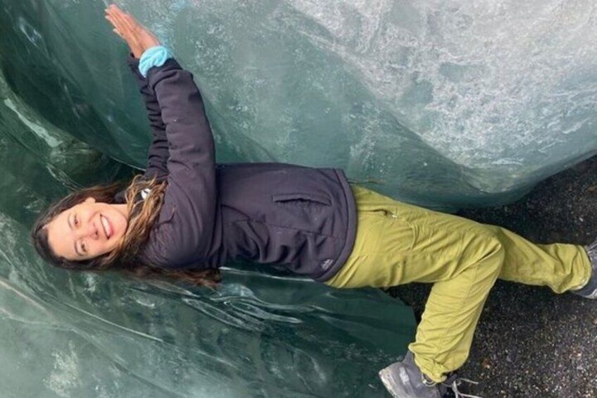 A person standing in front of a large ice formation. 2