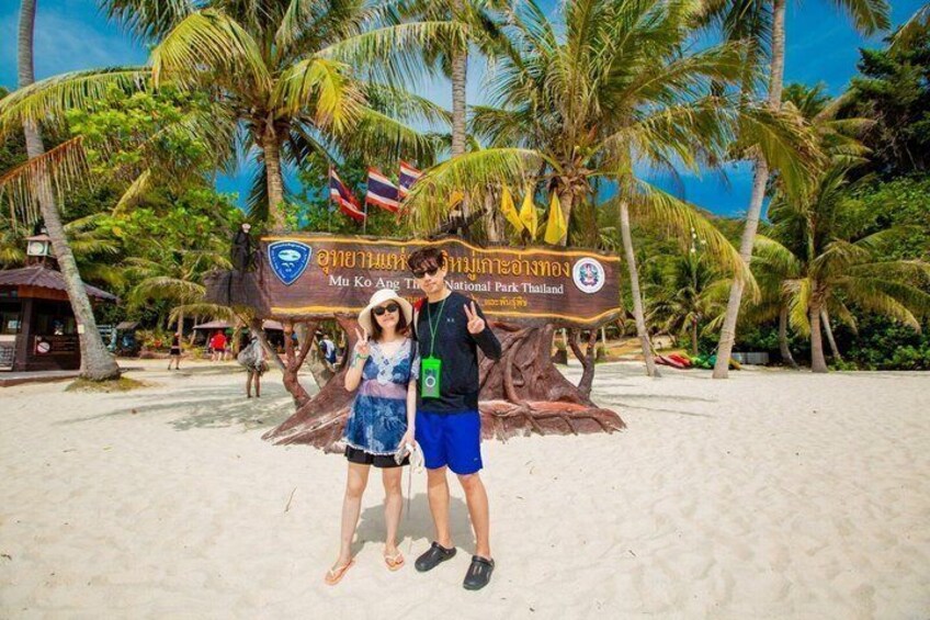A beach with palm trees and a sign for Mu Ko Ang Thong National Park Thailand. 4