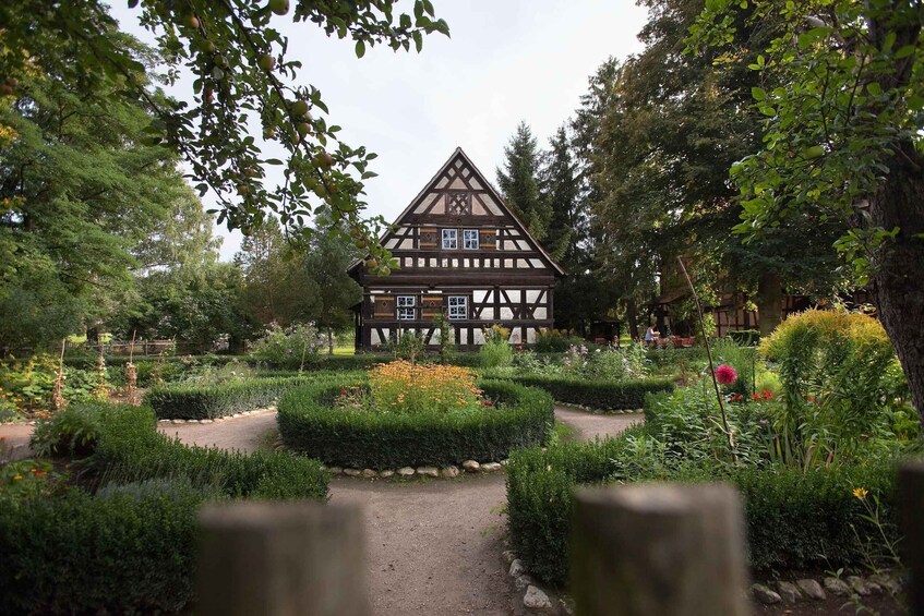 A traditional half-timbered house surrounded by a well-maintained garden with various plants and flowers. 3
