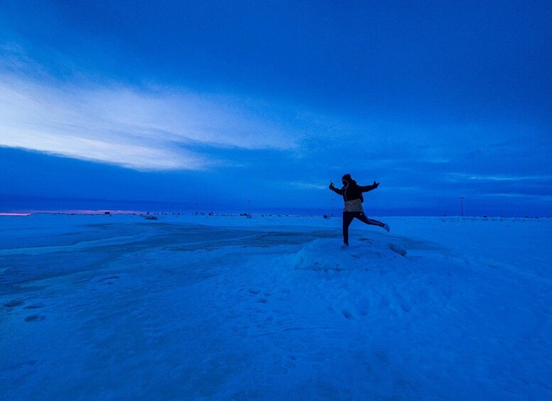 A person running on a snowy landscape at dusk. 2