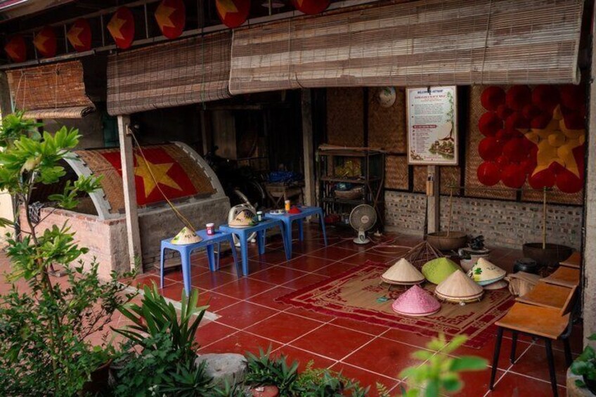A traditional Vietnamese restaurant with red tiled flooring, blue stools, and conical hats. 5