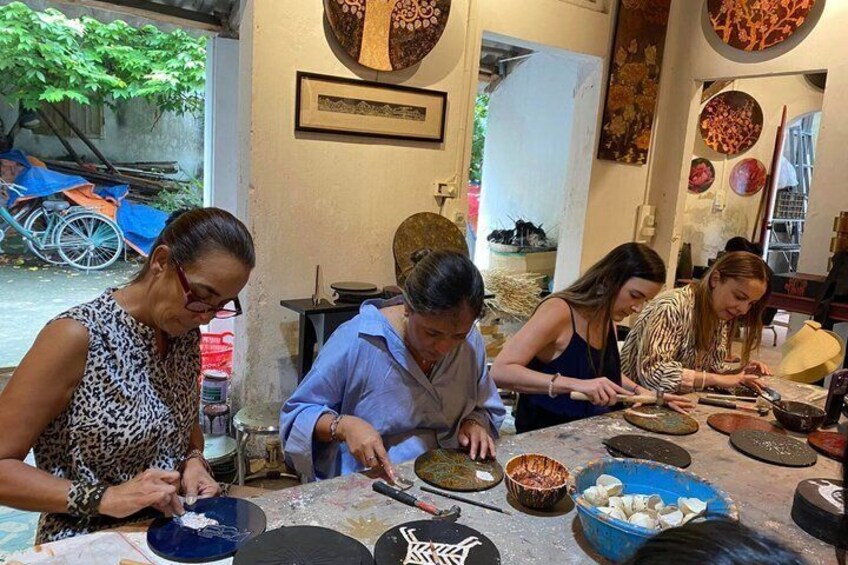 A group of people engaged in a cooking activity, with bowls of ingredients and utensils on a table. 1