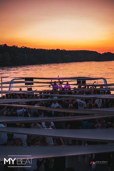 A sunset over a body of water with a crowd on a boat. 2