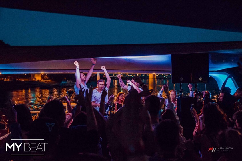 A crowd at a concert with people raising their hands. 3