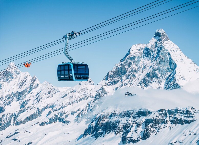 A cable car ascending a snow-covered mountain. 1