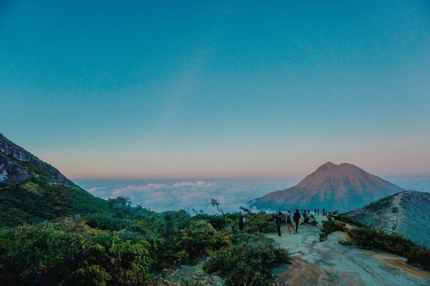 A mountainous landscape with a group of hikers on a trail. 3