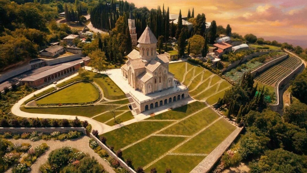 An aerial view of a historic church surrounded by landscaped gardens and a variety of trees. 3