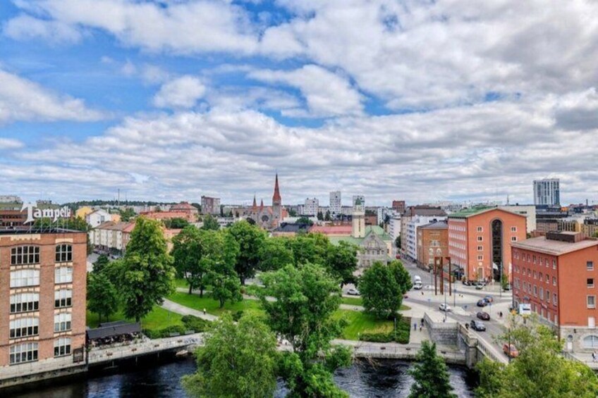 A cityscape with a river, green spaces, and historic buildings. 1