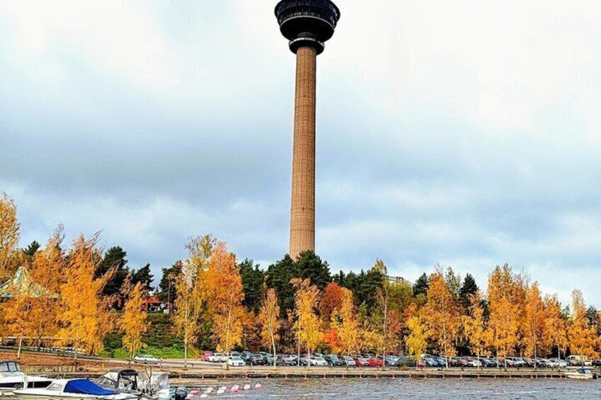 A tall tower, a parking lot, and autumn-colored trees. 3