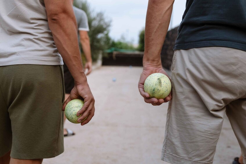 Two people holding round, speckled fruits. 1
