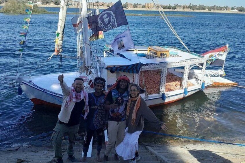 A boat with people on board, a flag, and a body of water. 3