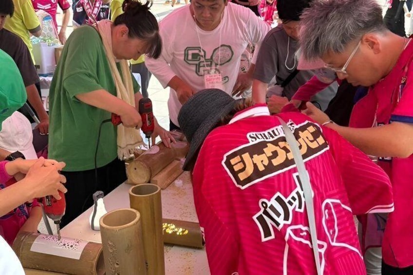 People engaged in a craft activity, possibly pottery or woodwork, with tools and materials on the table. 1