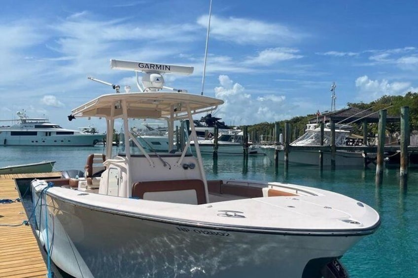 A boat docked at a marina with other boats in the background. 1
