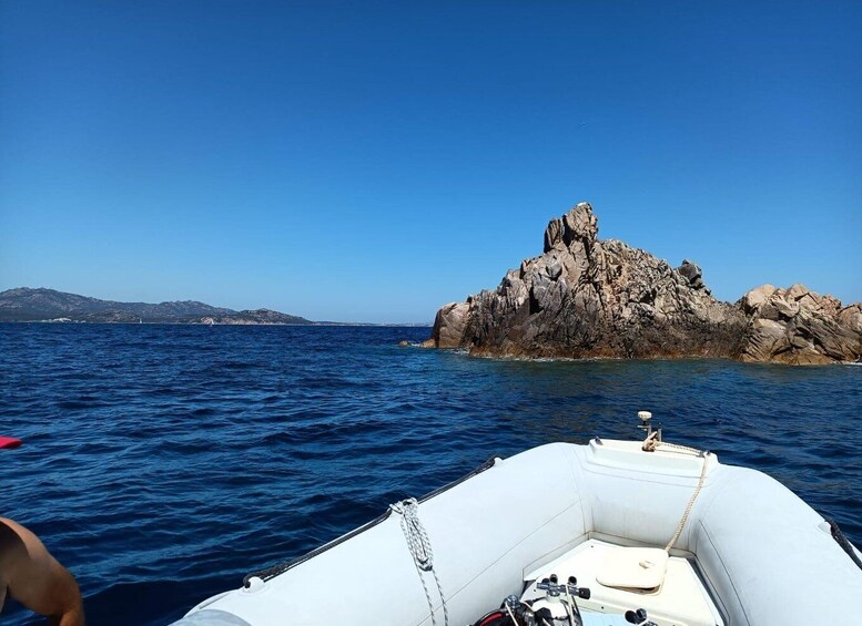 A boat on a calm sea with a rocky island in the distance. 4