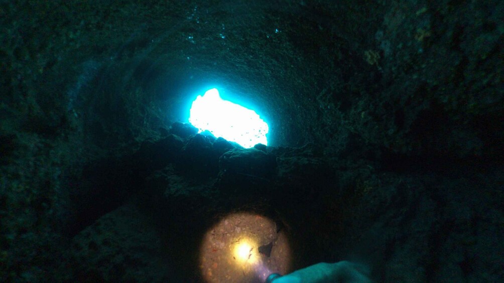 A cave entrance with a bright light at the top. 2