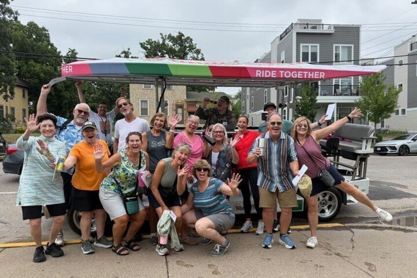 A group of people posing in front of a gas station with a 'Ride Together' banner. 1