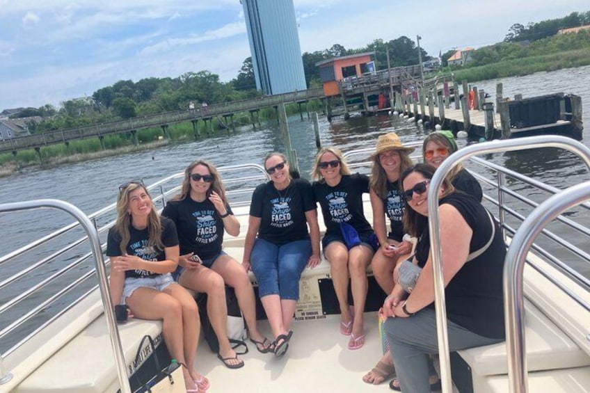 A group of people on a boat with a bridge and water in the background. 2