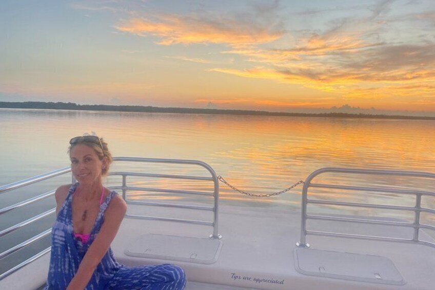 A person on a boat with a sunset in the background. 1