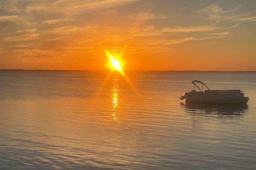 A boat on calm water during sunset. 4