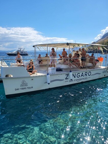 A boat named ZINGARO with passengers enjoying a sunny day out on clear blue waters. 2