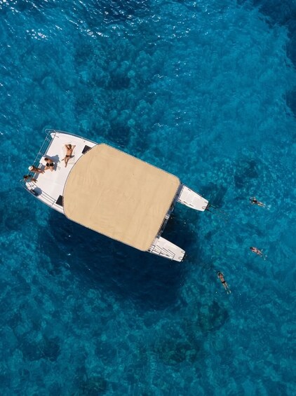 A boat with a sandy deck, surrounded by clear blue water. 1