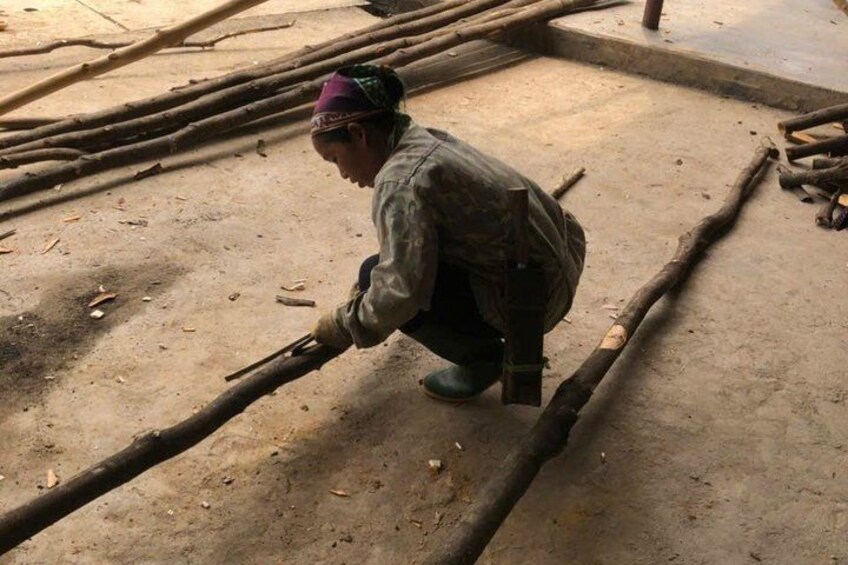 A person working with wooden logs on a concrete floor. 2