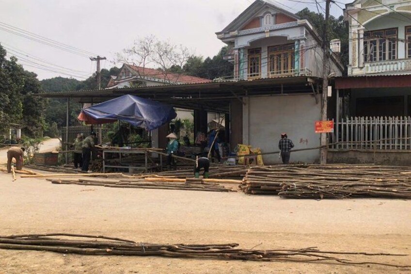 A rural scene with a building, a person walking, and construction materials. 5
