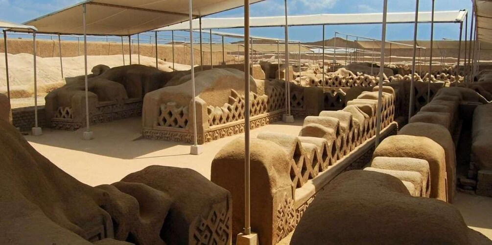 A series of ancient, intricately carved stone seats under a large, open structure. 5