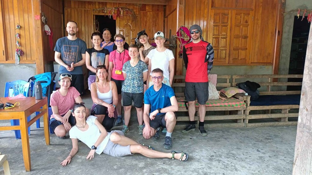 A group of people gathered in a rustic wooden building with a concrete floor. 4