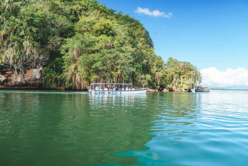 A boat named 'HAKUNA MATATA II' on calm water with a forested cliff in the background. 4