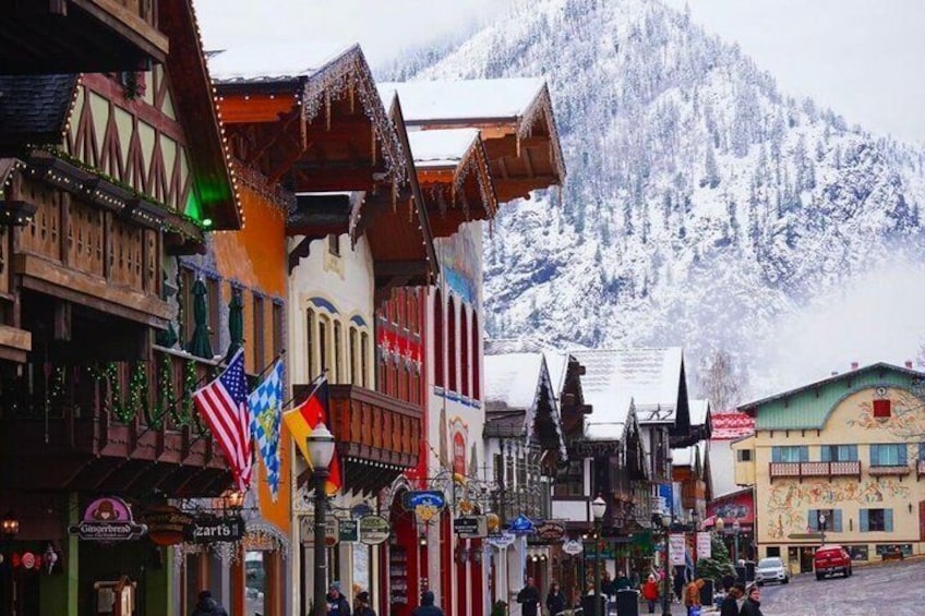 A snow-covered mountain town with traditional wooden buildings and flags. 1