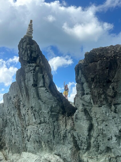 A person standing on a rock formation with a clear sky in the background. 2