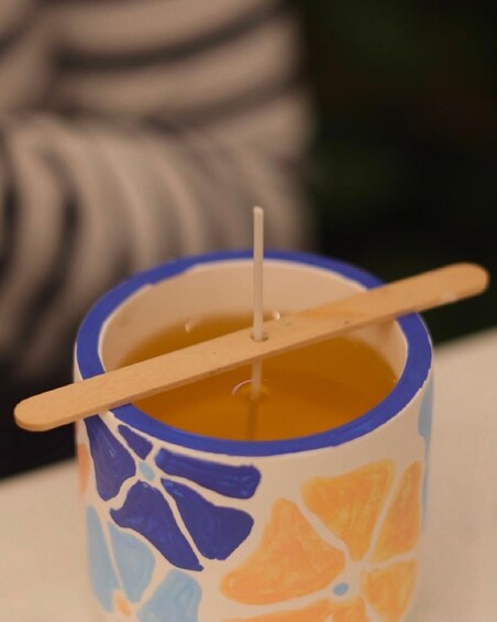 A ceramic mug with a floral pattern and a wooden spoon inside it. 1