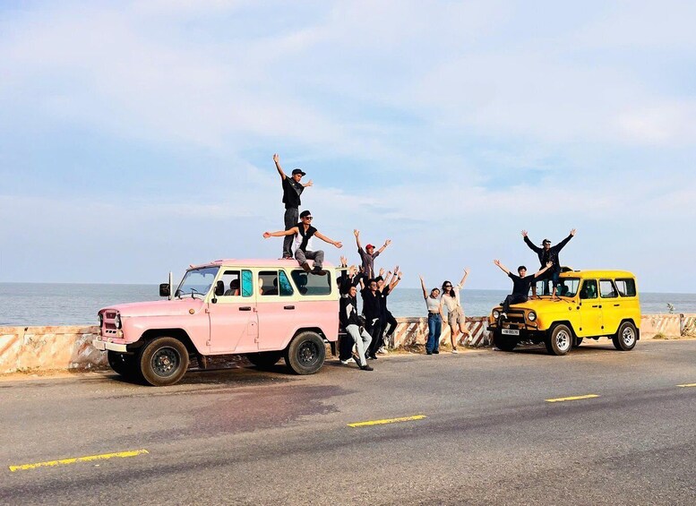 A group of people celebrating on a road with a pink and yellow vehicle. 2