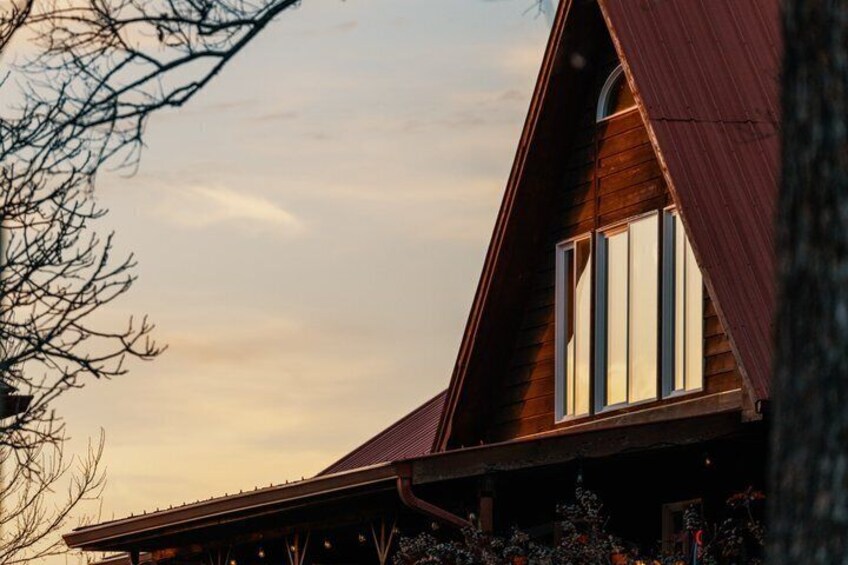 A wooden cabin with a sloped roof and large windows. 4