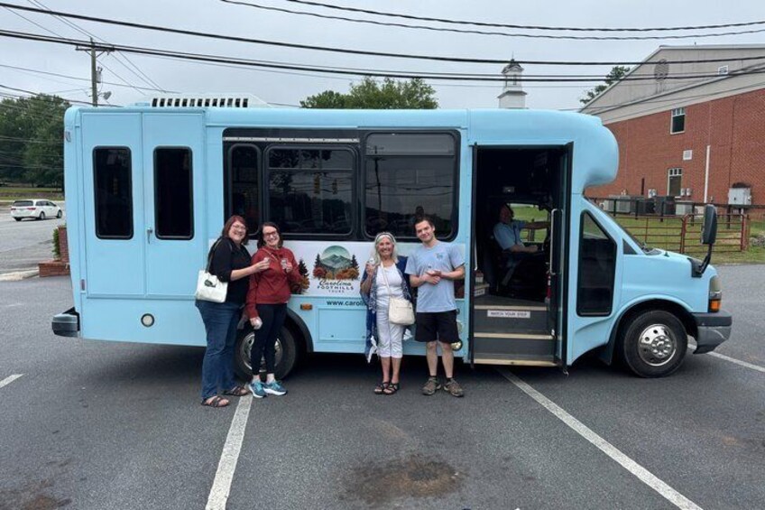 A light blue food truck parked in a lot with people standing in front. 5