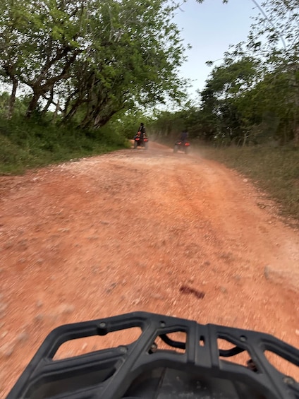 A dirt road with two off-road vehicles. 4