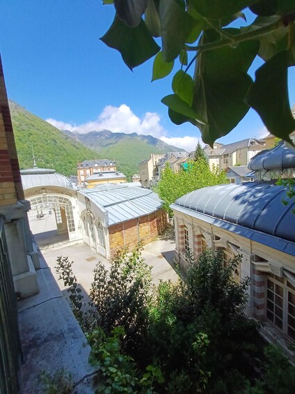 A courtyard with buildings, a mountain in the background, and a clear sky. 5