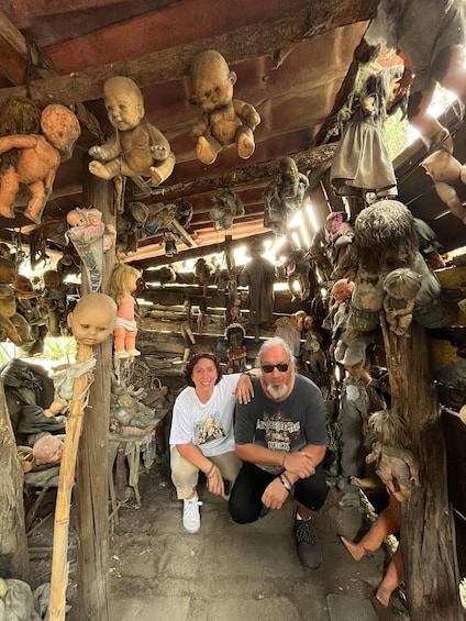 A room filled with various dolls and figures, some hanging from the ceiling and others placed on shelves. 5
