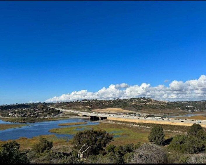 A coastal landscape with a bridge, water bodies, and a clear sky. 3