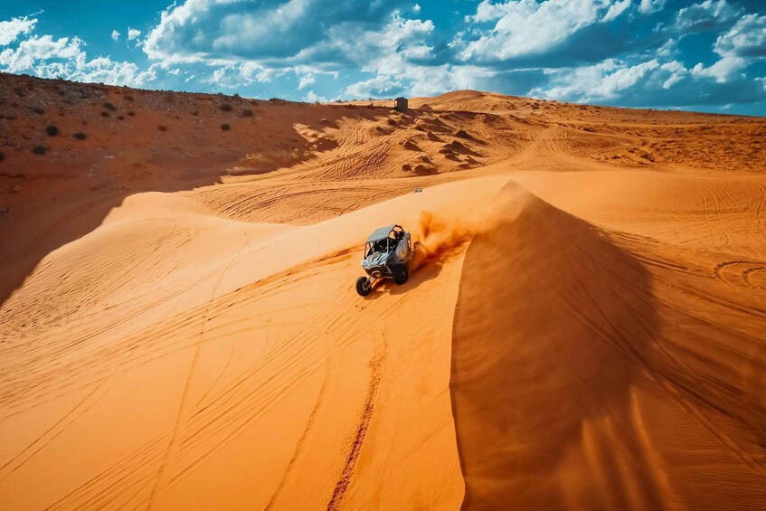 A vehicle navigating a sand dune in a desert landscape. 4