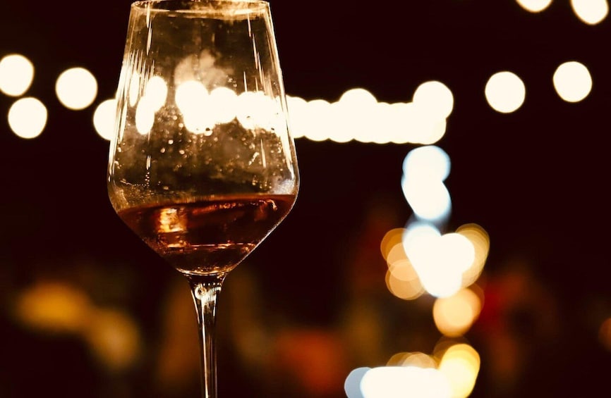A wine glass with a blurred cityscape in the background. 3