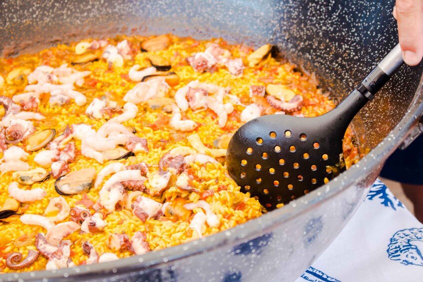 A large pot of paella with seafood and rice. 2