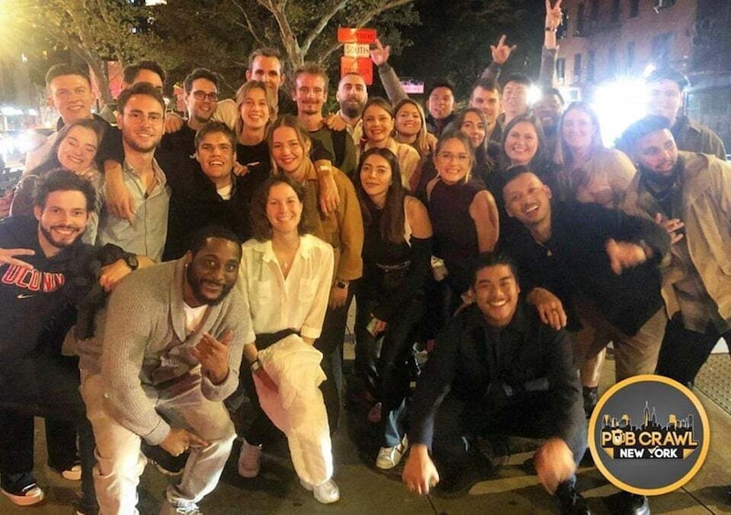 A group of people posing for a photo on a city street at night. 4