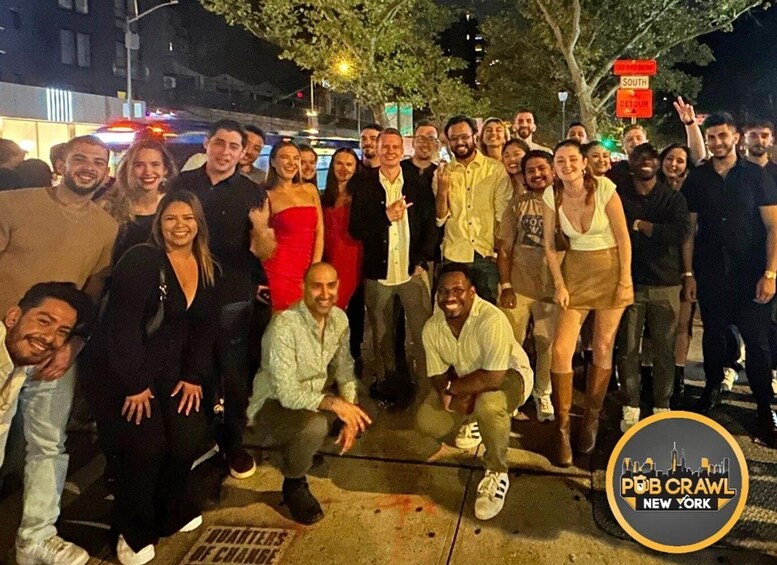 A group of people posing for a photo on a city street at night. 5