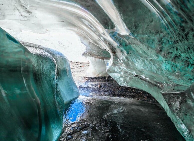 An ice cave with turquoise and white ice formations. 4